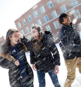 Two male and two female students surrounded by flying snow.